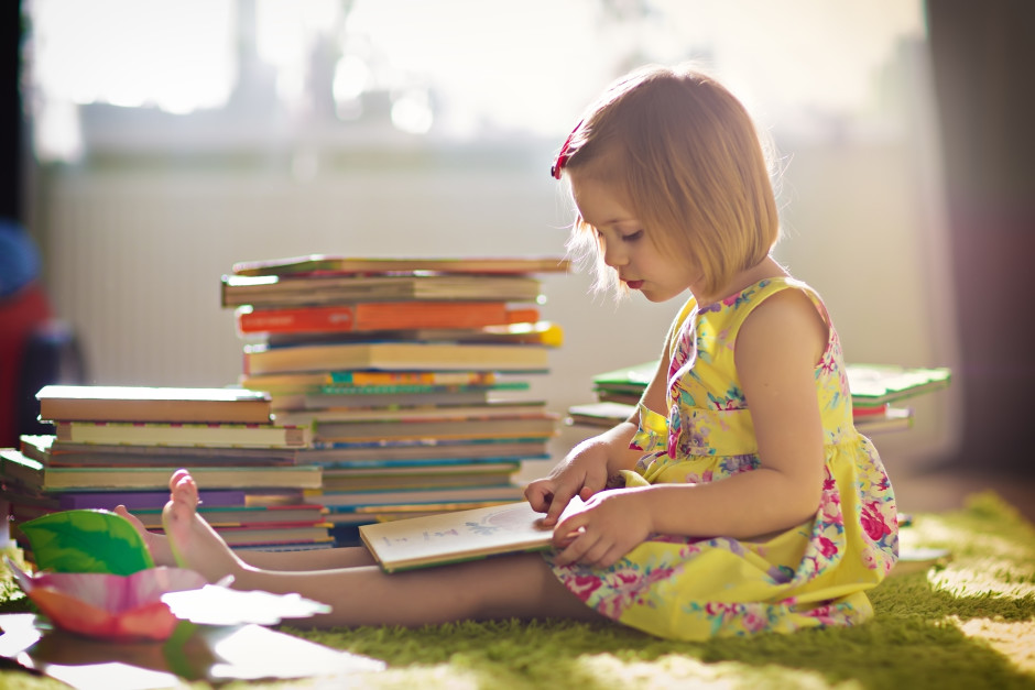 girl reading with stack of books - shutterstock_221592391